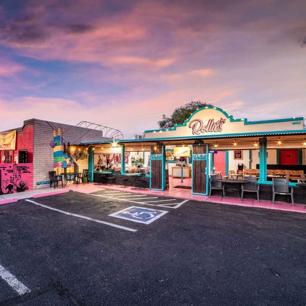 Rollie's Mexican Patio exterior at dusk, featuring vibrant murals, outdoor seating, and a colorful facade.