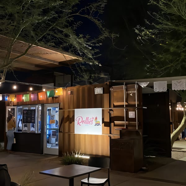 Rollies Mexican Patio at night, with a customer at the order window and colorful lights strung above.