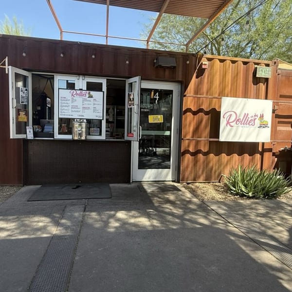 Rollies Mexican Patio, a rustic brown shipping container restaurant with an open service window and door.